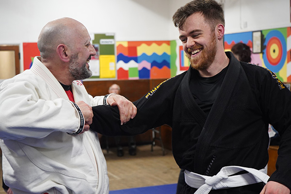 Sensei Luca Narducci sharing a laugh with a student during a class
